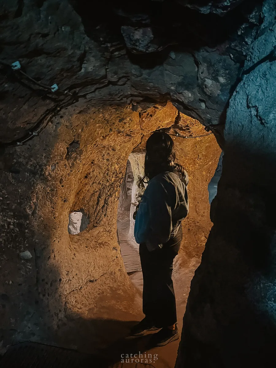 A woman stands at a door in the Underground City of Derinkuyu, in this Cappadocia travel guide