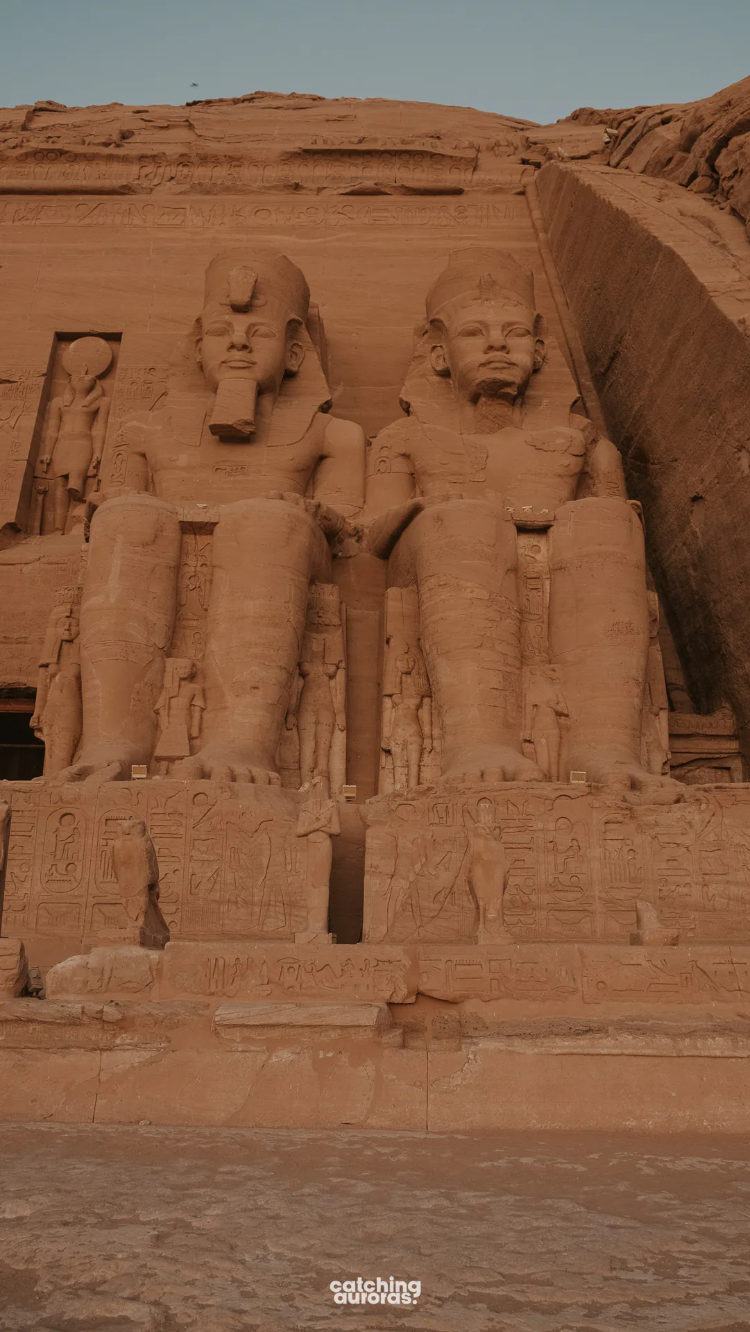 Abu Simbel sunrise: seated colossi of Ramesses II just before the light reaches their faces