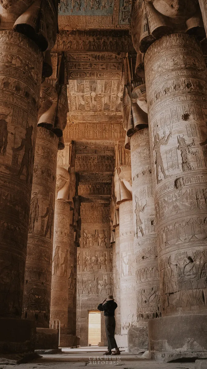 A girl standing inside the hypostyle hall in Dendera Temple Egypt