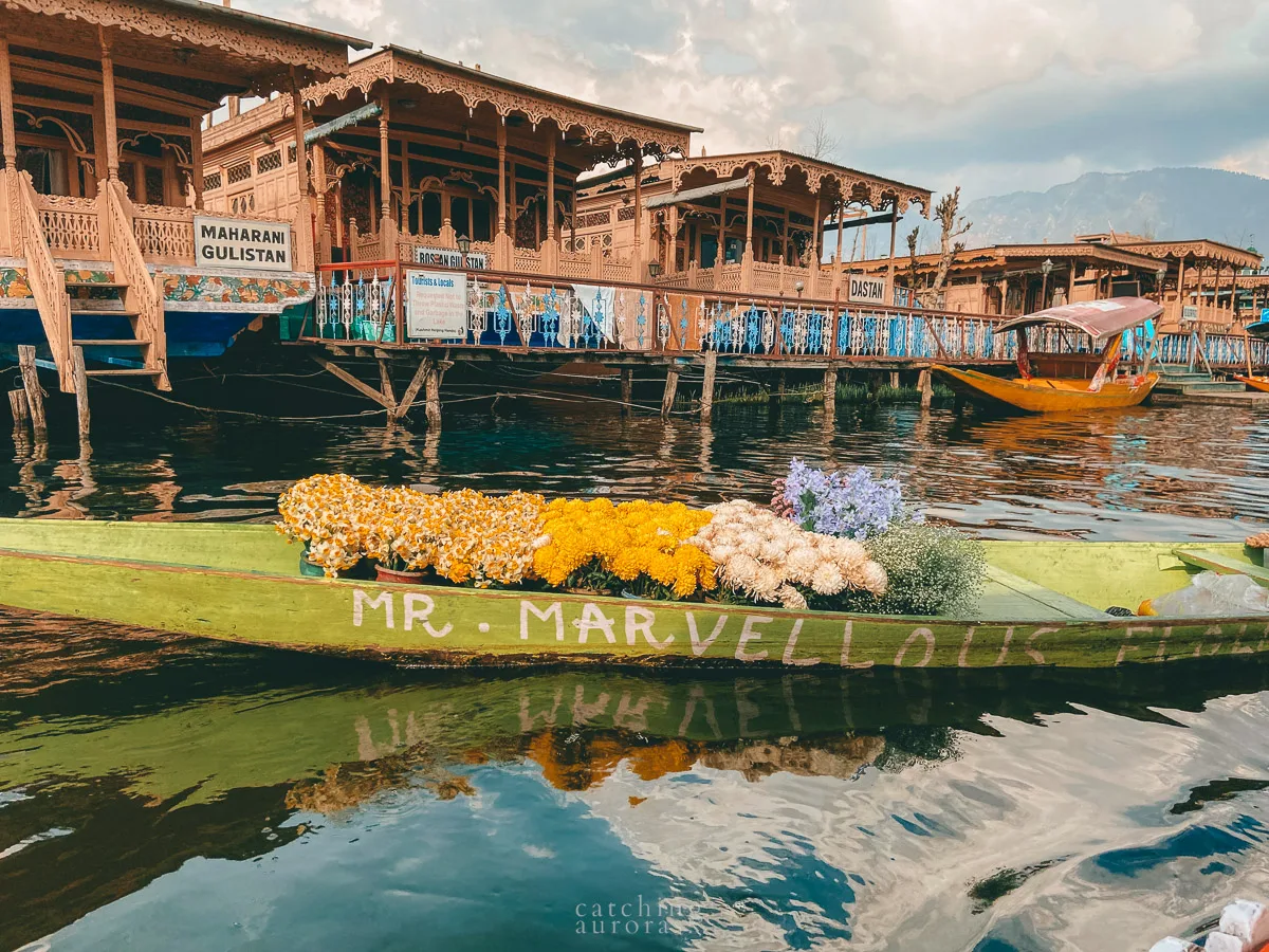 A shikara filled with flower floats by in Dal Lake, Srinagar