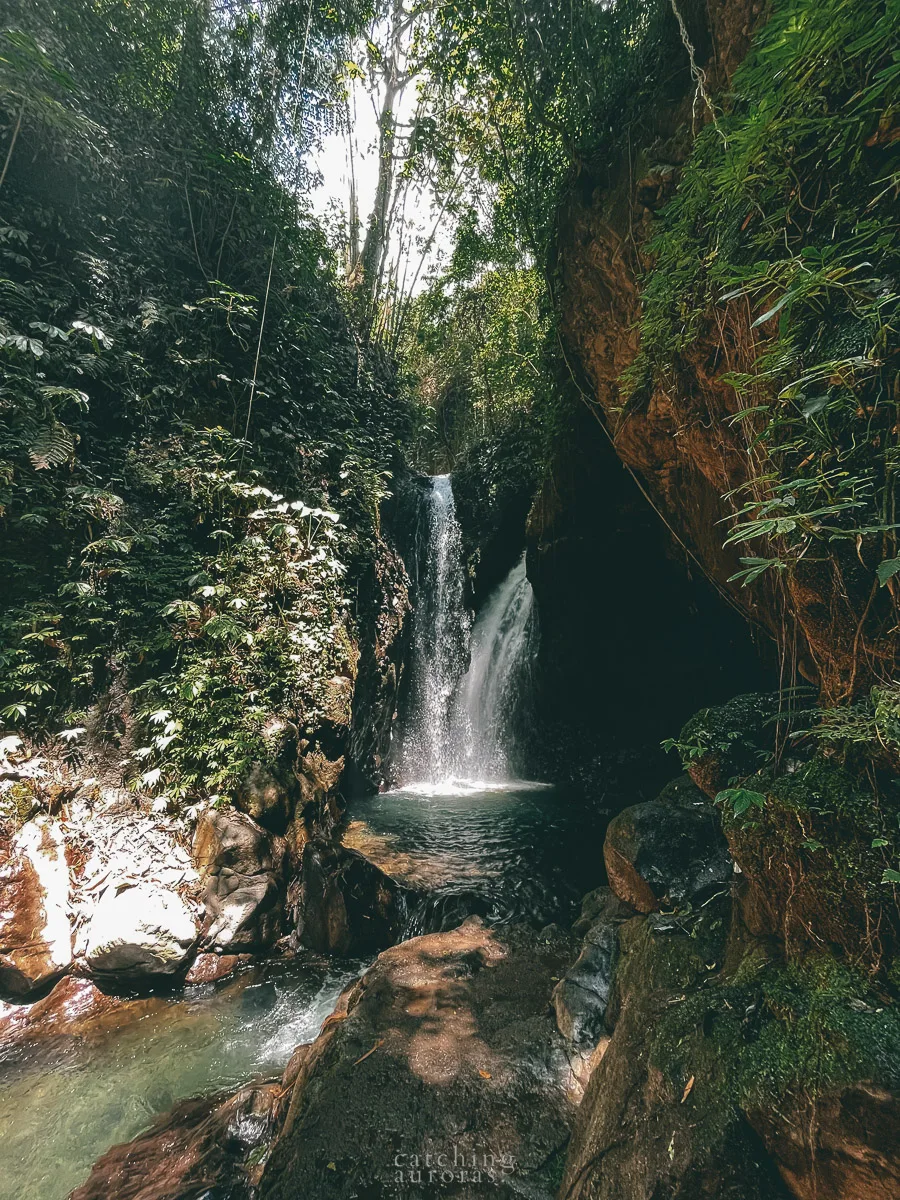 Two short waterfalls flow down into a pool of water