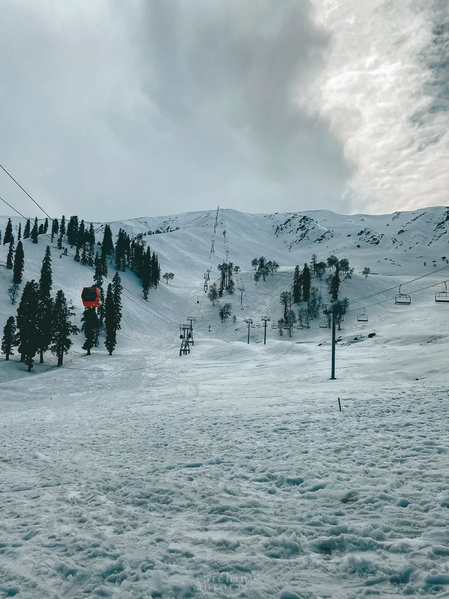 A Gondola line runs over a snowy mountain peak