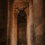 A traveller stands between the colourful columns of Esna Temple