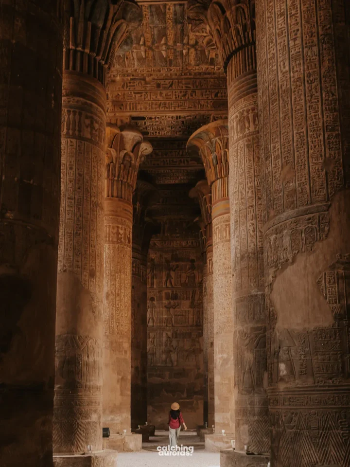 A traveller stands between the colourful columns of Esna Temple