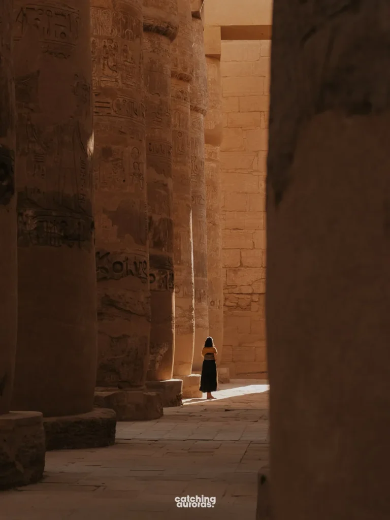 A girl walks amidst the columns of the Hypostyle Hall in Karnak Temple, Luxor