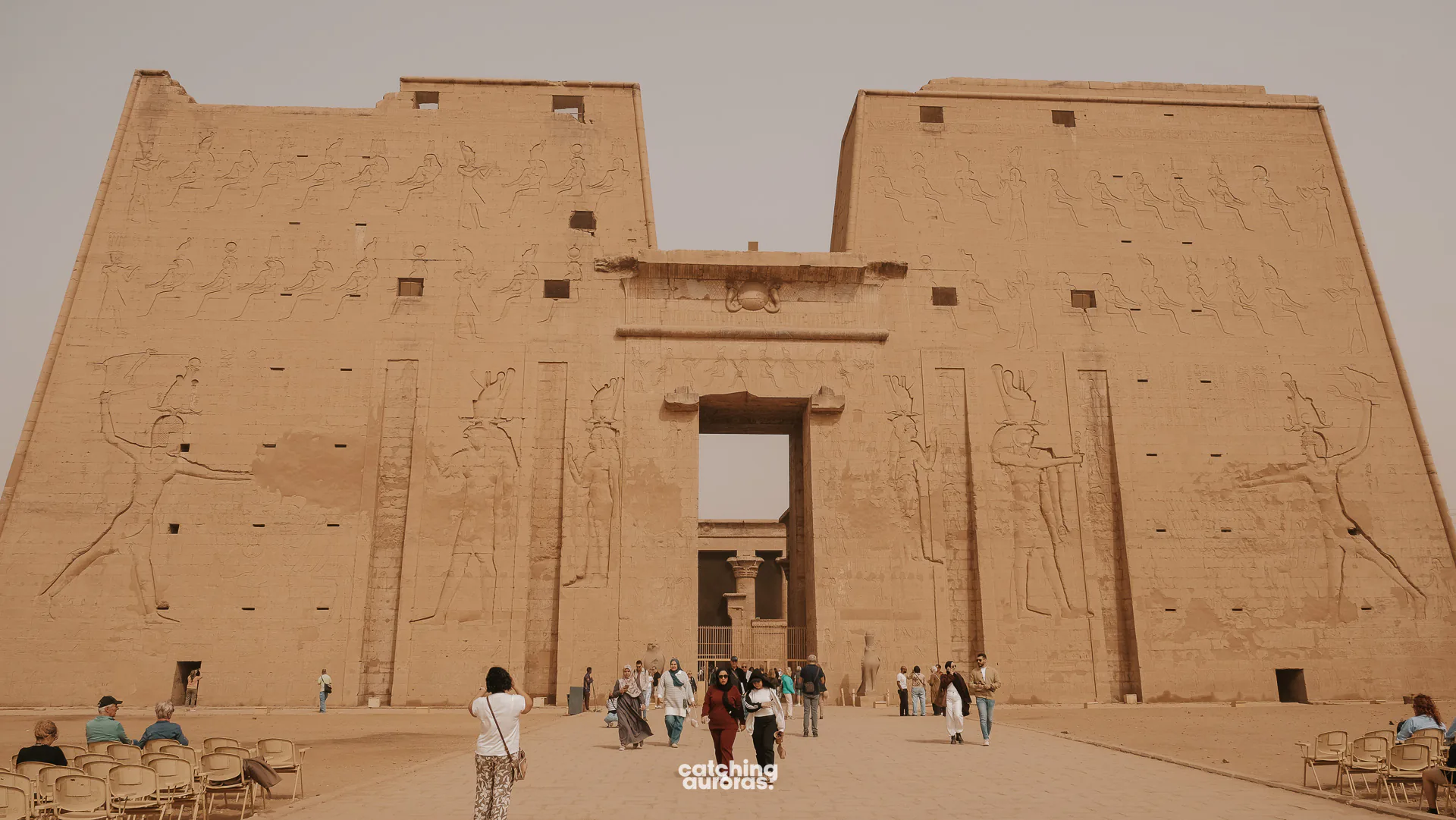 Massive entrance pylons of the Temple of Horus at Edfu, carved with figures of the king and gods.