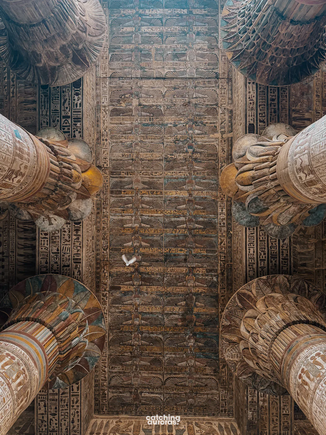Painted columns and colorful ceiling inside Esna Temple, covered in colourful figures and hieroglyphs