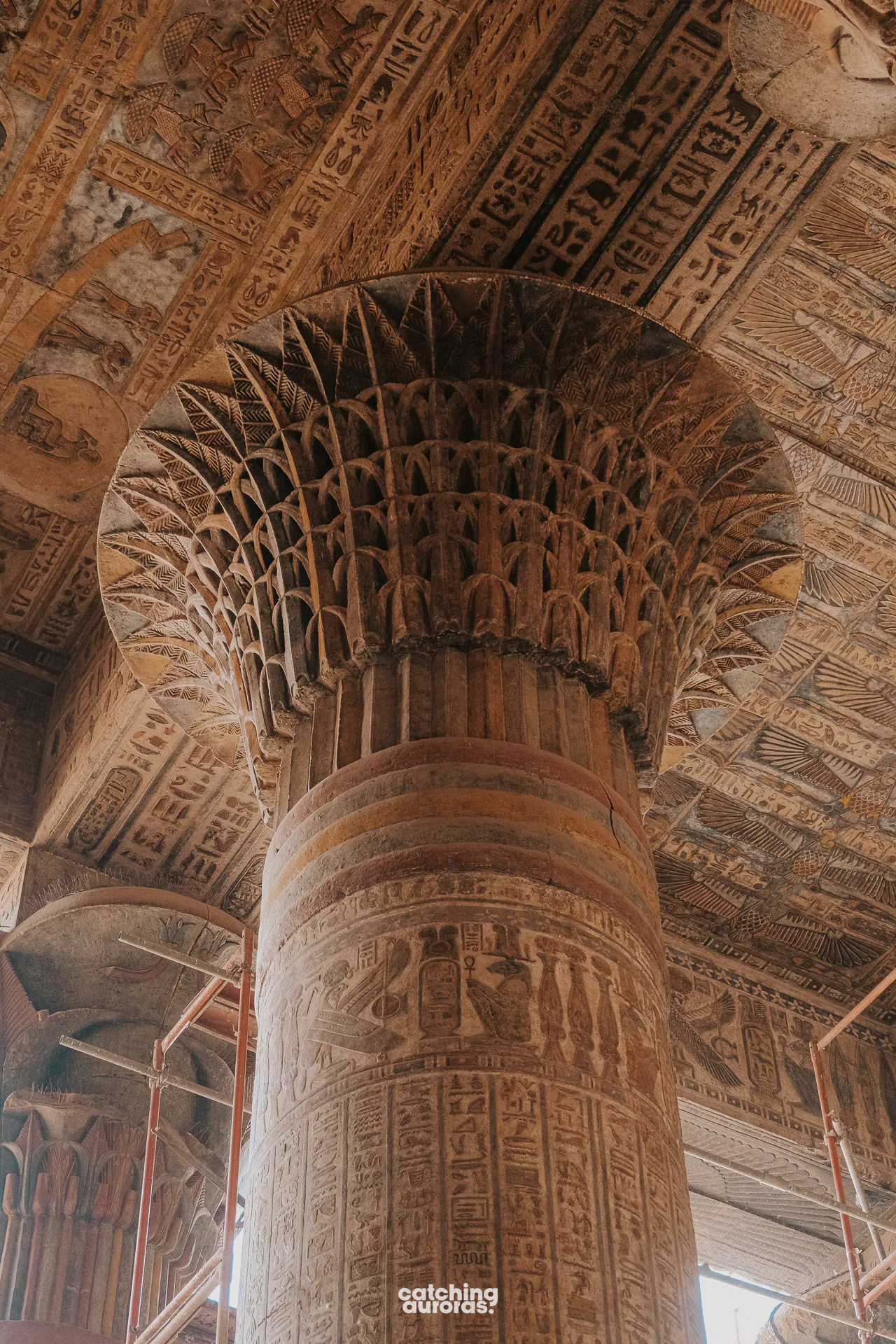 Painted columns inside Esna Temple, covered in colourful figures and hieroglyphs.