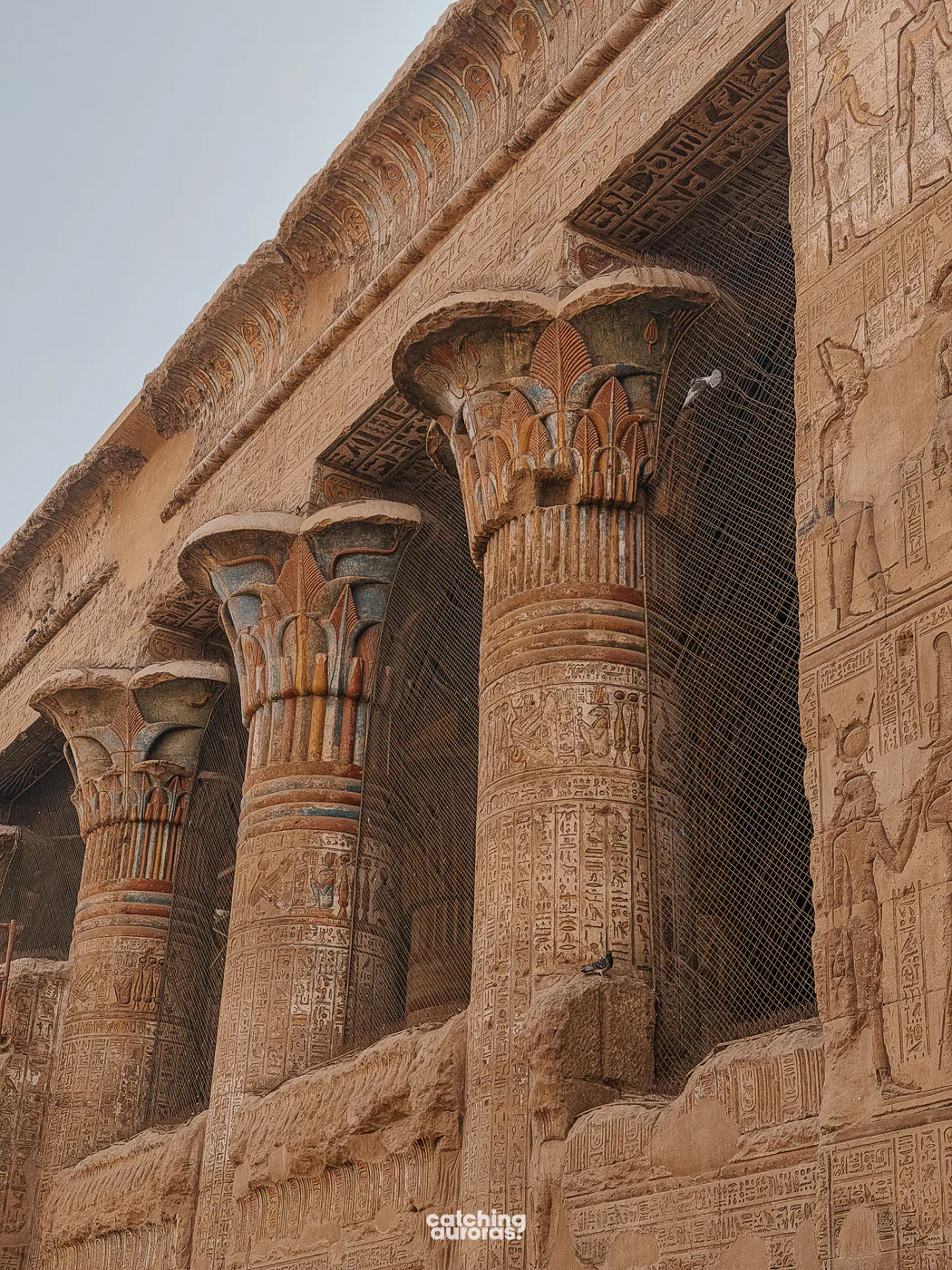 Painted columns of Esna Temple, covered in colourful figures and hieroglyphs