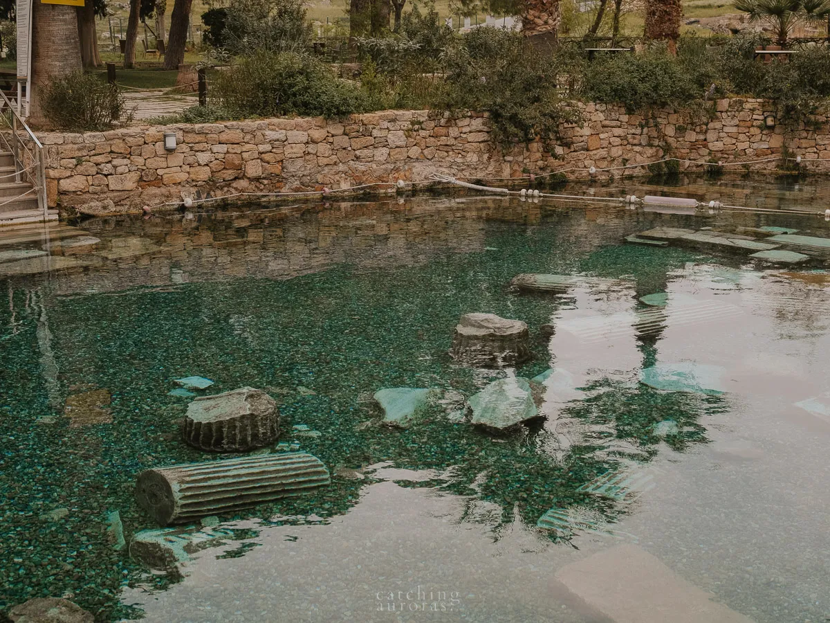 A clear crystal pool with ancient artifacts at the bottom