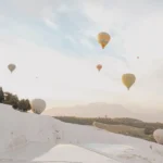 A cover image of hot air balloons over white terraces