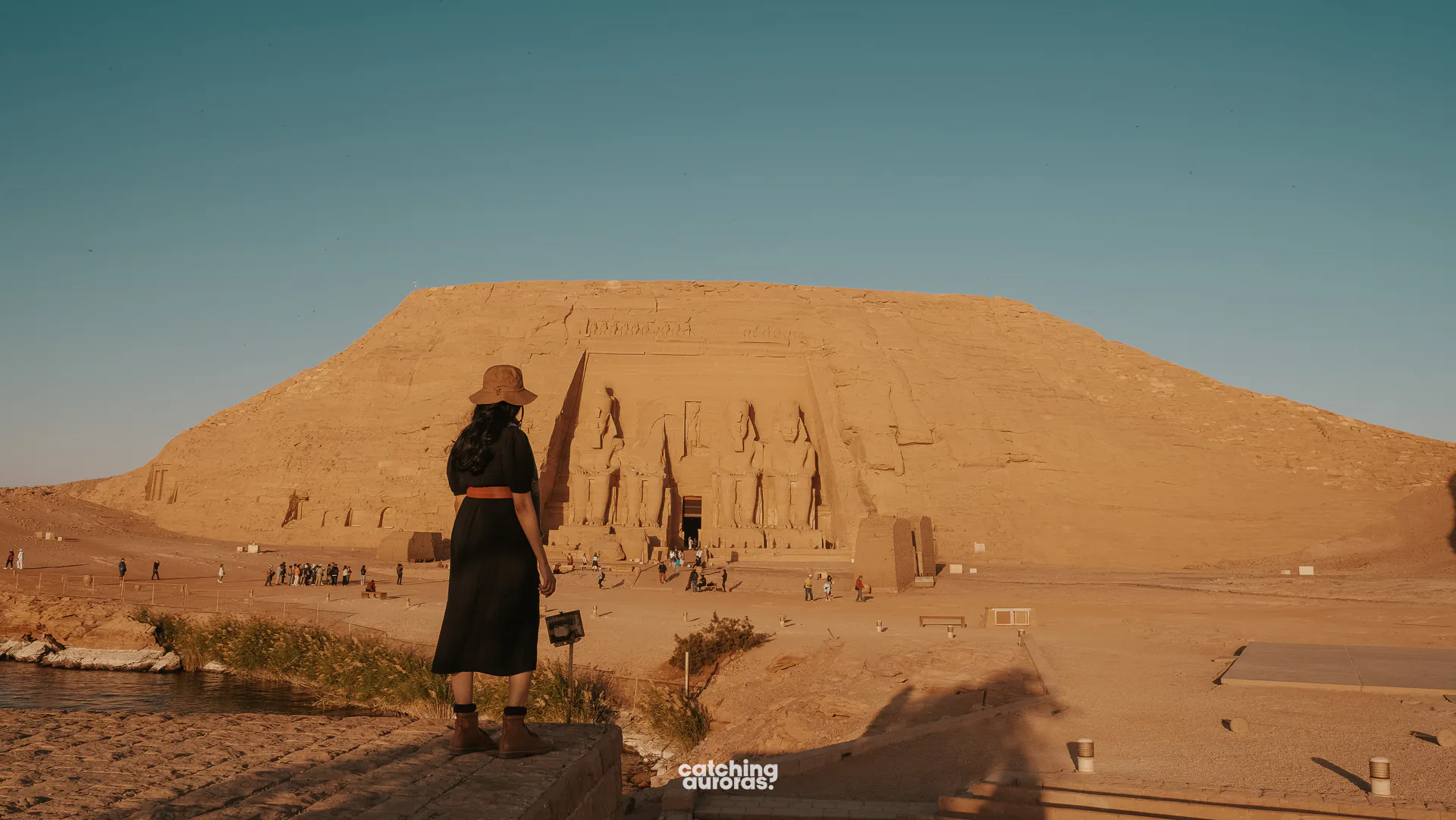 Traveller in a black dress standing before the Great Temple of Abu Simbel in Egypt