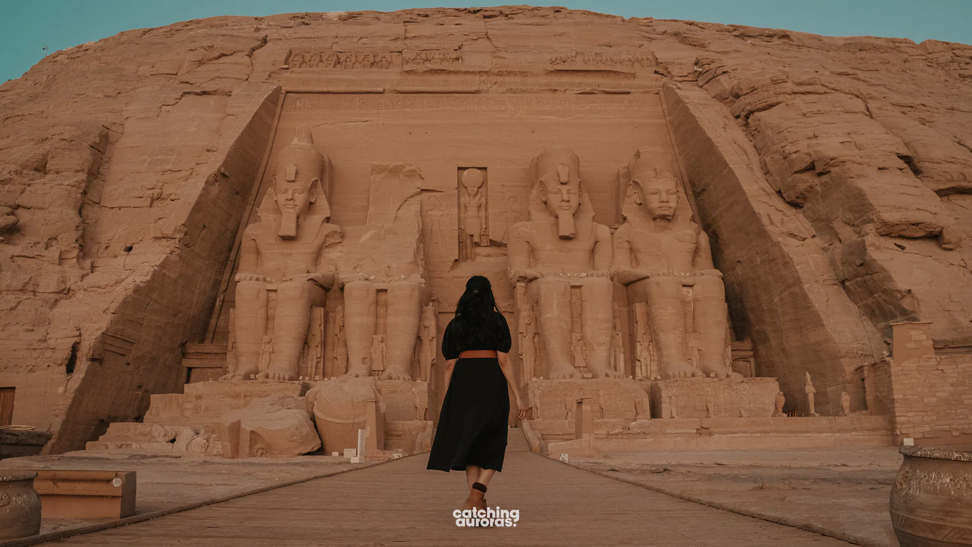 Traveller in a black dress in front of the Great Temple of Abu Simbel at 6 AM