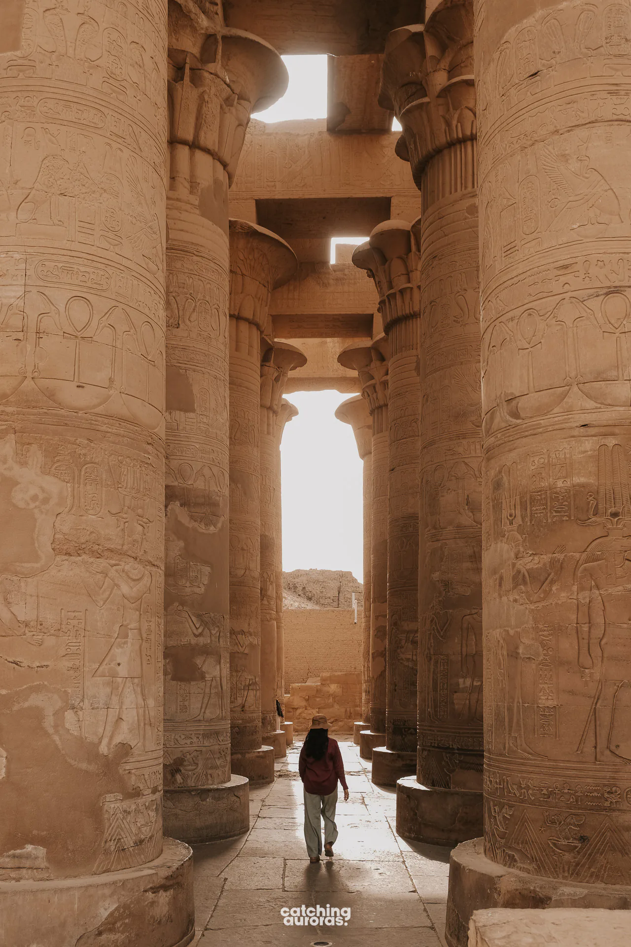 Traveller standing among the columns at Kom Ombo Temple, with the Nile beyond