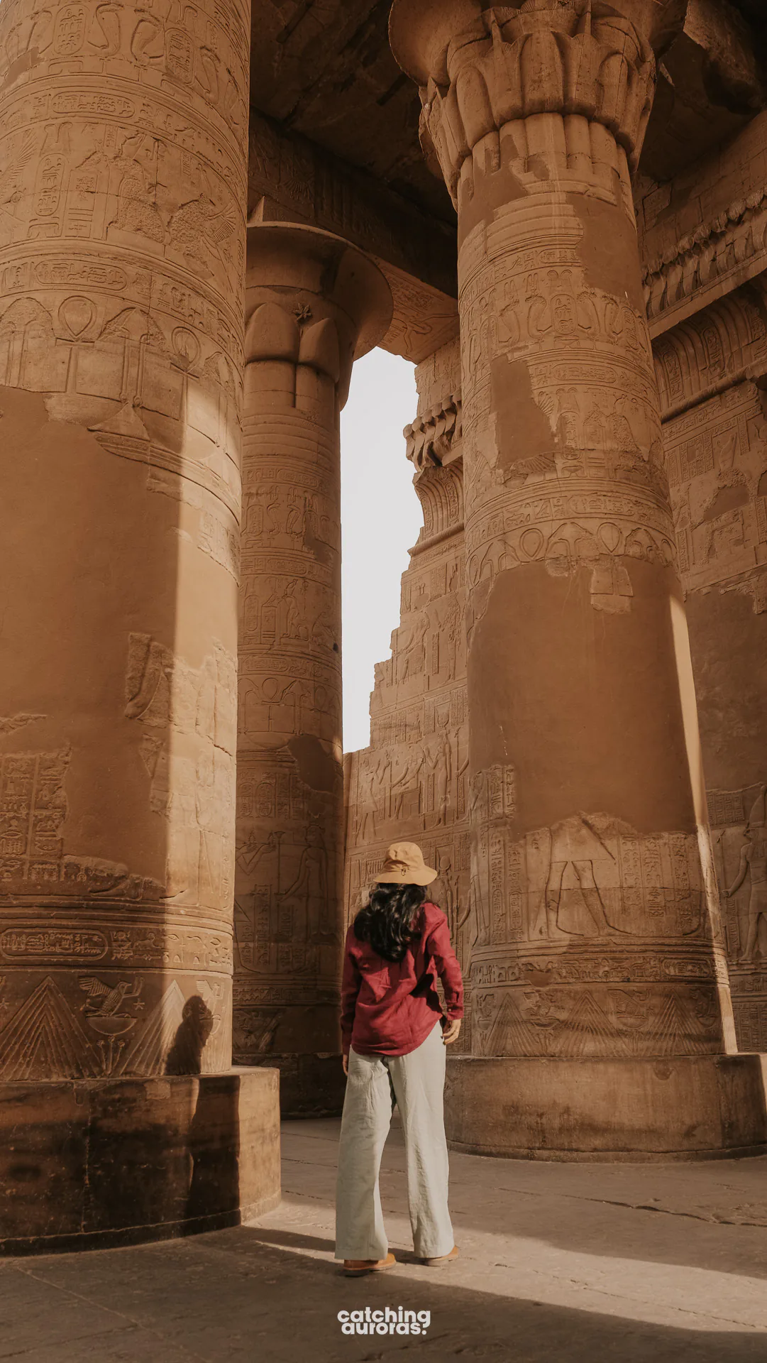Traveller standing among the columns at Kom Ombo Temple, with the Nile beyond