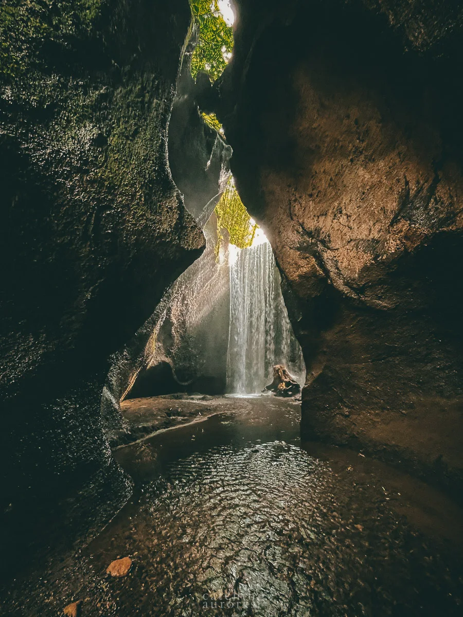 Light rays falling over a waterfall in a cave in this bali waterfalls near ubud